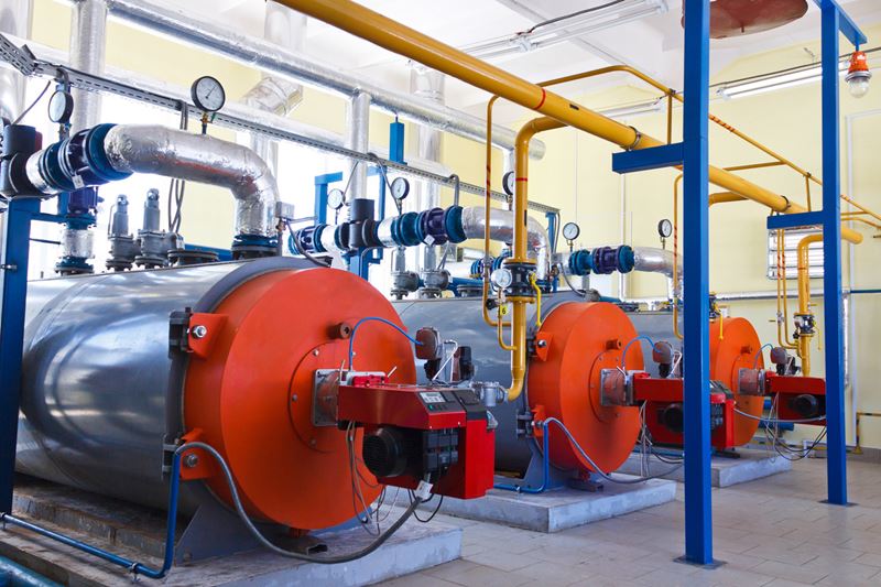 Three red and silver pressure vessels in a large room